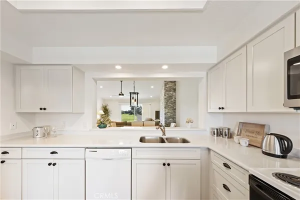 a kitchen with stainless steel appliances a sink stove and white cabinets