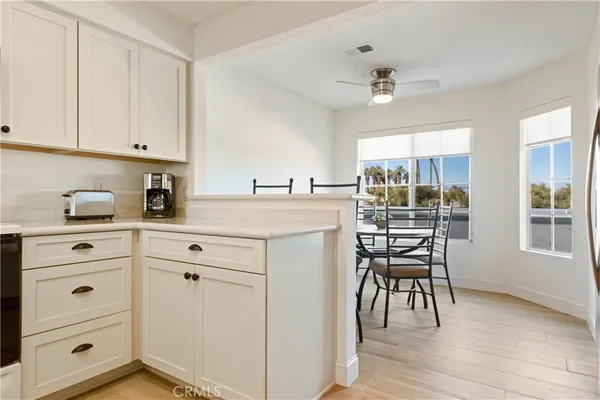 a kitchen with a white cabinets and chairs