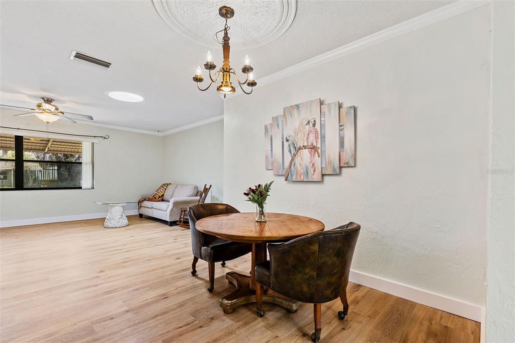 1855 Pine Tree Drive Edgewater, FL 32141 - Photo 11 of 26 a view of a dining room with furniture wooden floor and chandelier