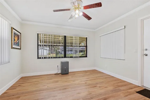 a view of an empty room with window and wooden floor