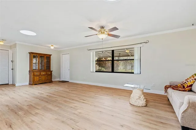 a view of an empty room with window and wooden floor