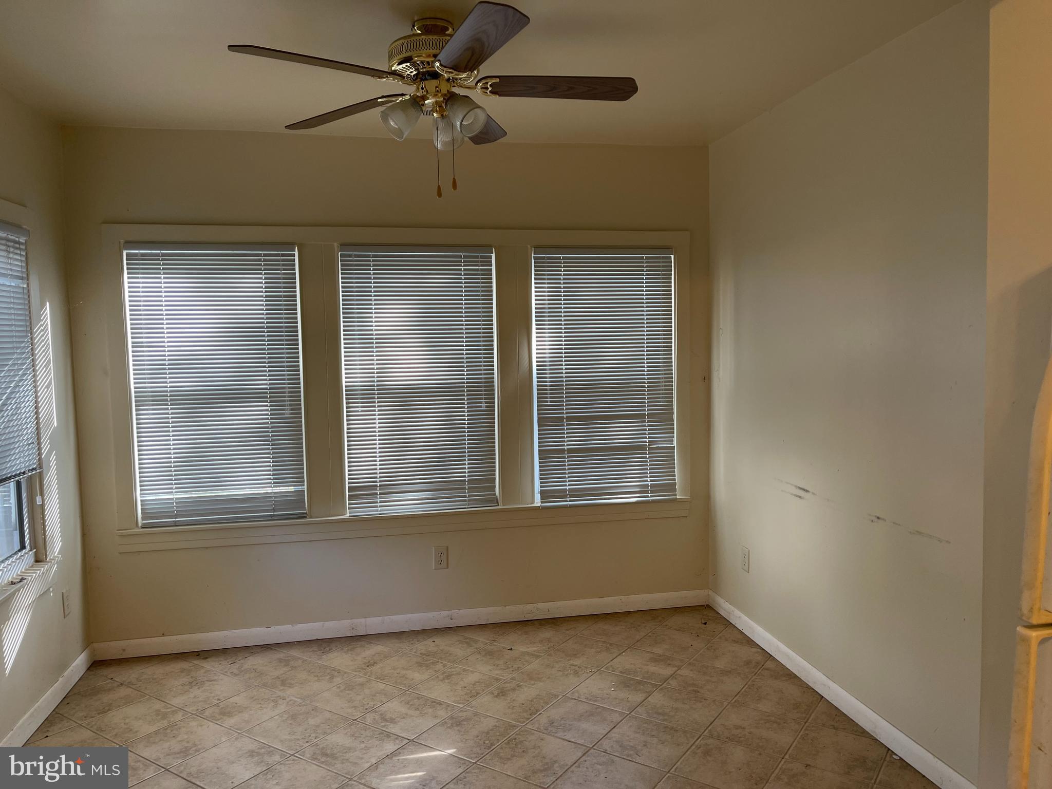 7968 Telegraph Road Severn, MD 21144 - Photo 18 of 26 an empty room with wooden floor fan and windows