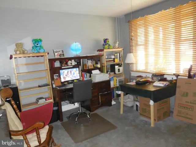 a view of a workspace with furniture and a window