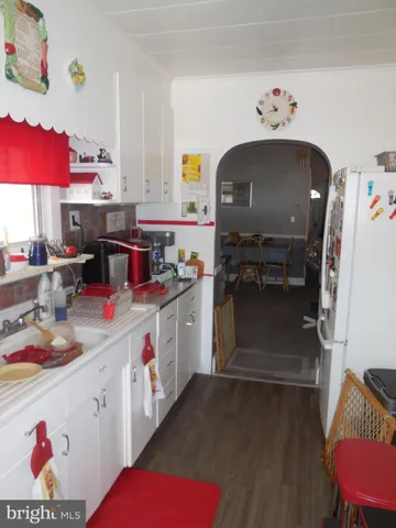 a kitchen with stainless steel appliances granite countertop a stove a sink dishwasher and a dining table with the bookshelf