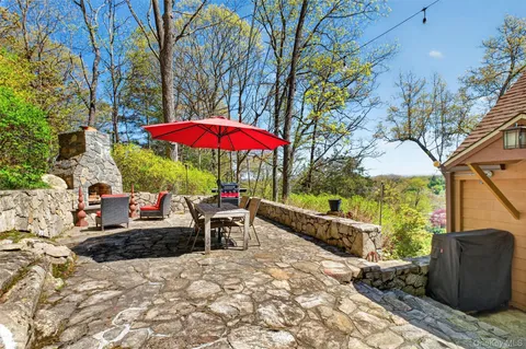 a view of a patio with a table and chairs under an umbrella with a fire pit