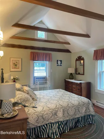 a bedroom with a bed and dresser with mirror