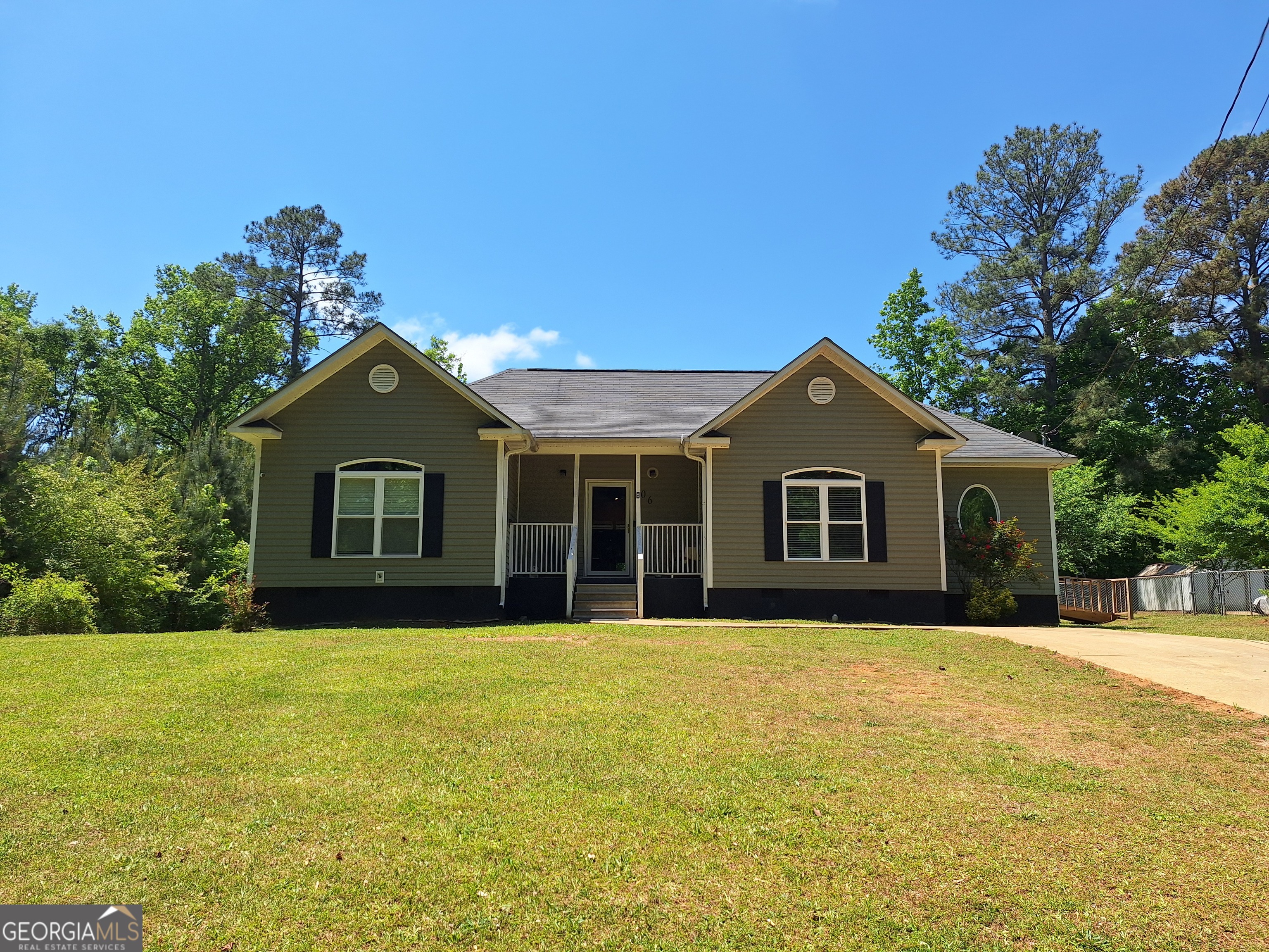 a front view of house with yard and trees in the background