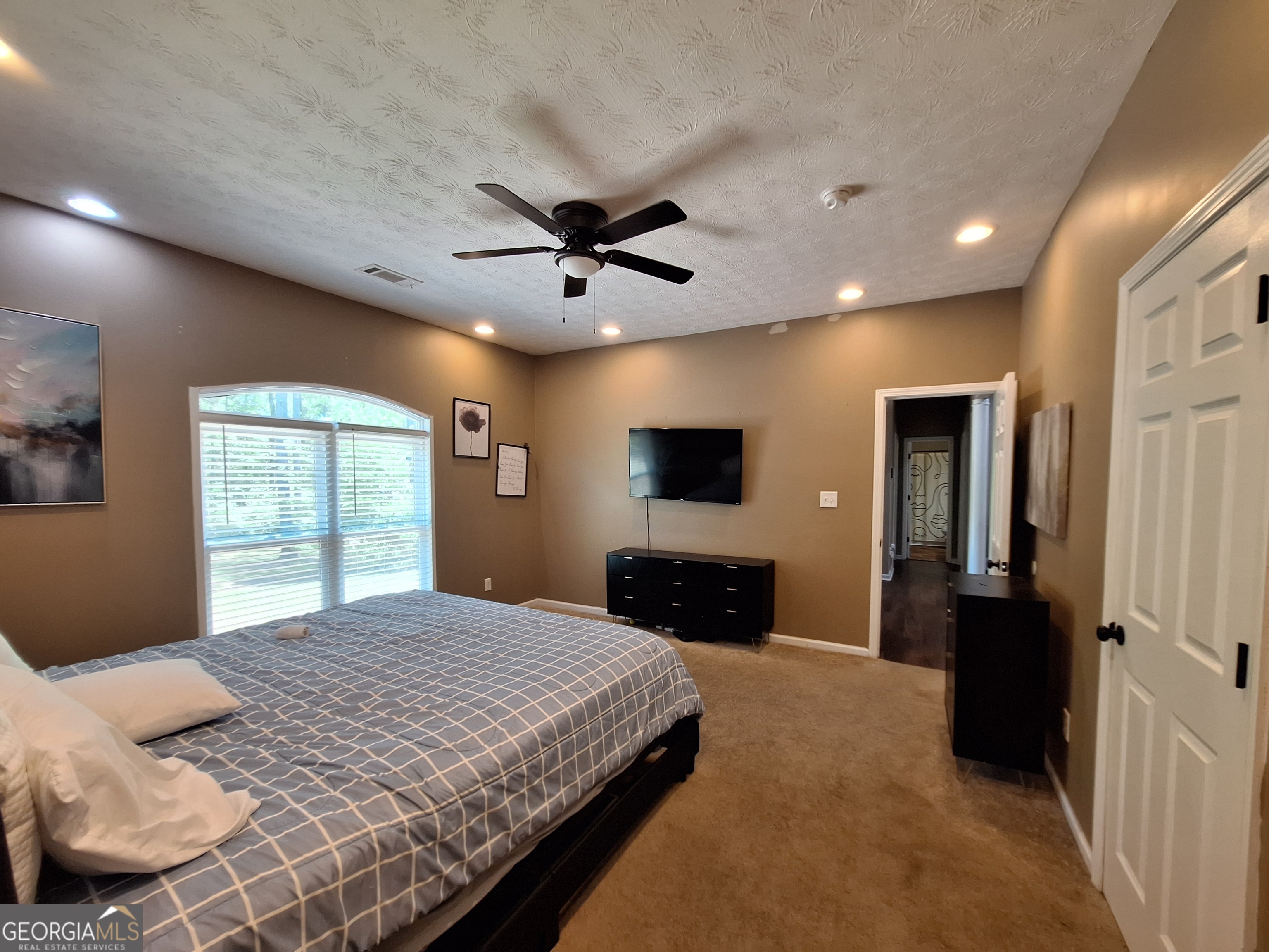 806 Springfield Drive Lafayette, AL 36862 - Photo 13 of 19 a bedroom with a large bed a flat tv screen and a dresser