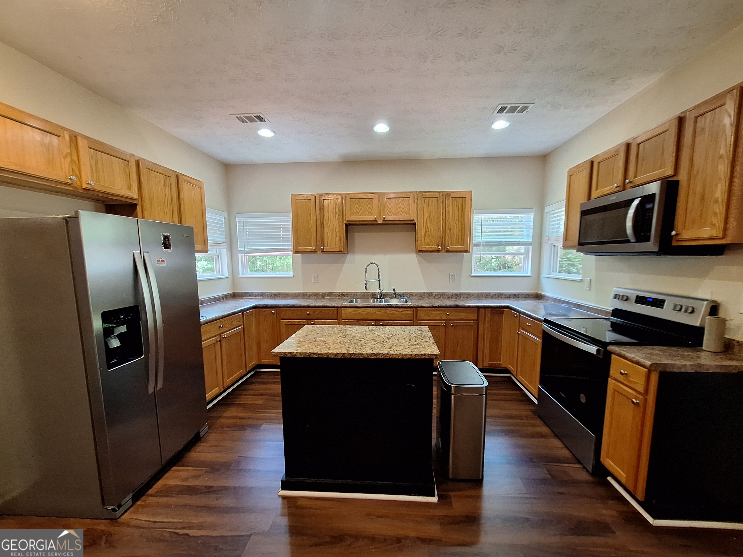 806 Springfield Drive Lafayette, AL 36862 - Photo 5 of 19 a kitchen with stainless steel appliances granite countertop a refrigerator a stove a sink dishwasher and microwave with wooden floor