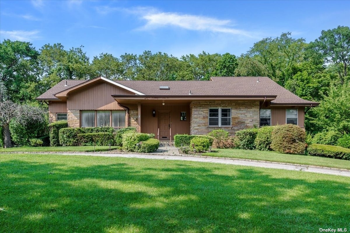 a front view of a house with a yard and green space