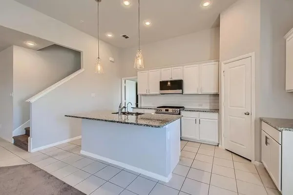 a kitchen with stainless steel appliances granite countertop a sink and a stove