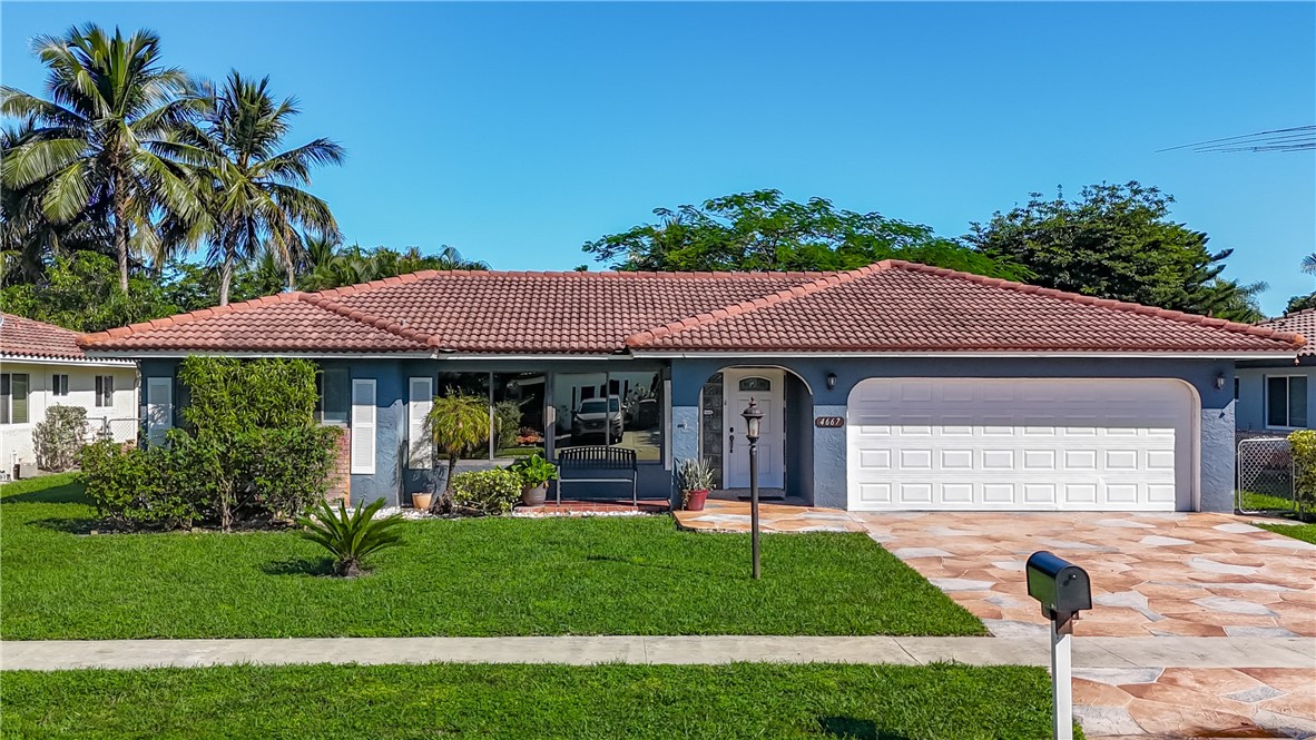 4667 Baldric Street Boca Raton, FL 33428 - Photo 3 of 32 a front view of a house with a garden