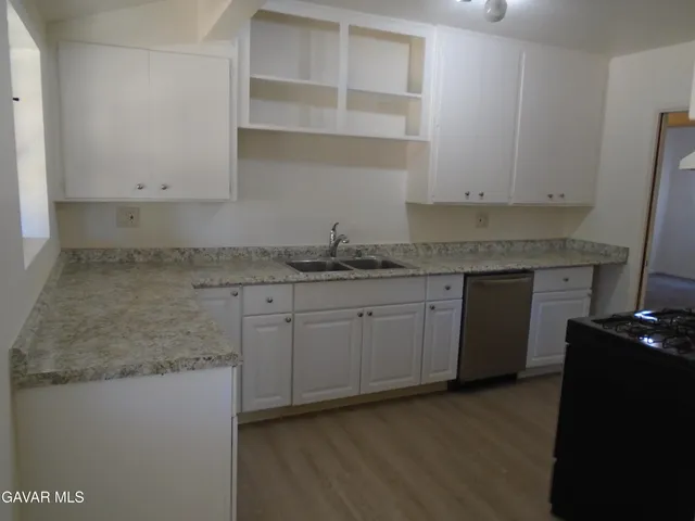 a kitchen with granite countertop cabinets stainless steel appliances and a sink