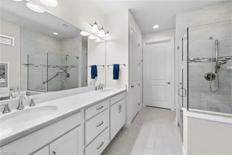 a spacious bathroom with a shower sink double mirror and shower