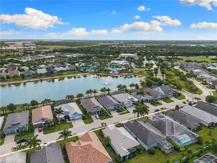 an aerial view of a city with lots of residential buildings and ocean view in back
