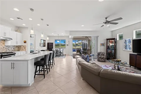 a living room with furniture a flat screen tv and kitchen view