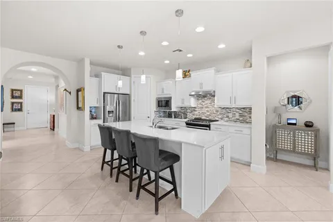 a kitchen with kitchen island cabinets and chairs