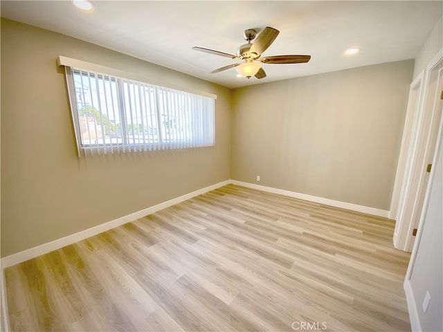 a view of a room with wooden floor and a window