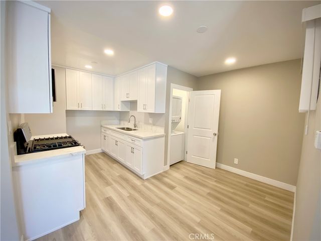 a kitchen with white cabinets and white appliances