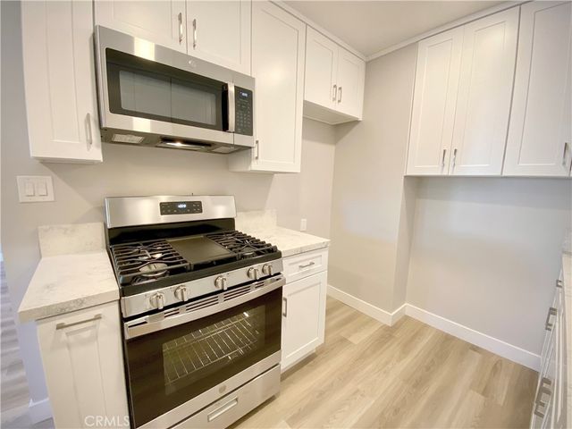 a kitchen with stainless steel appliances granite countertop a stove and a microwave