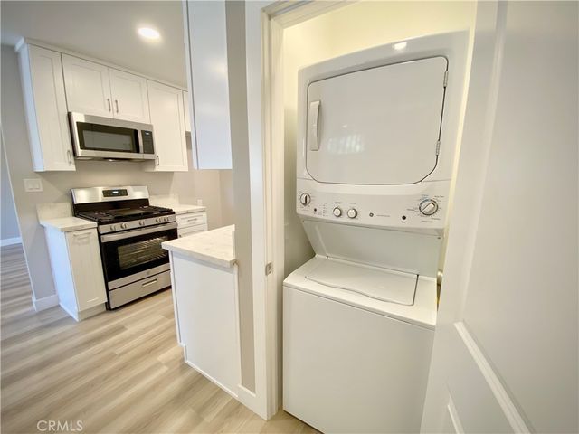 a kitchen with a microwave a stove and a sink with wooden floor