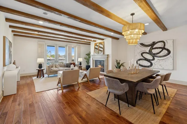 a view of a dining room with furniture a chandelier and wooden floor