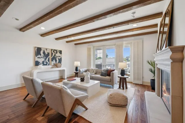 a kitchen with white cabinets and wooden floor
