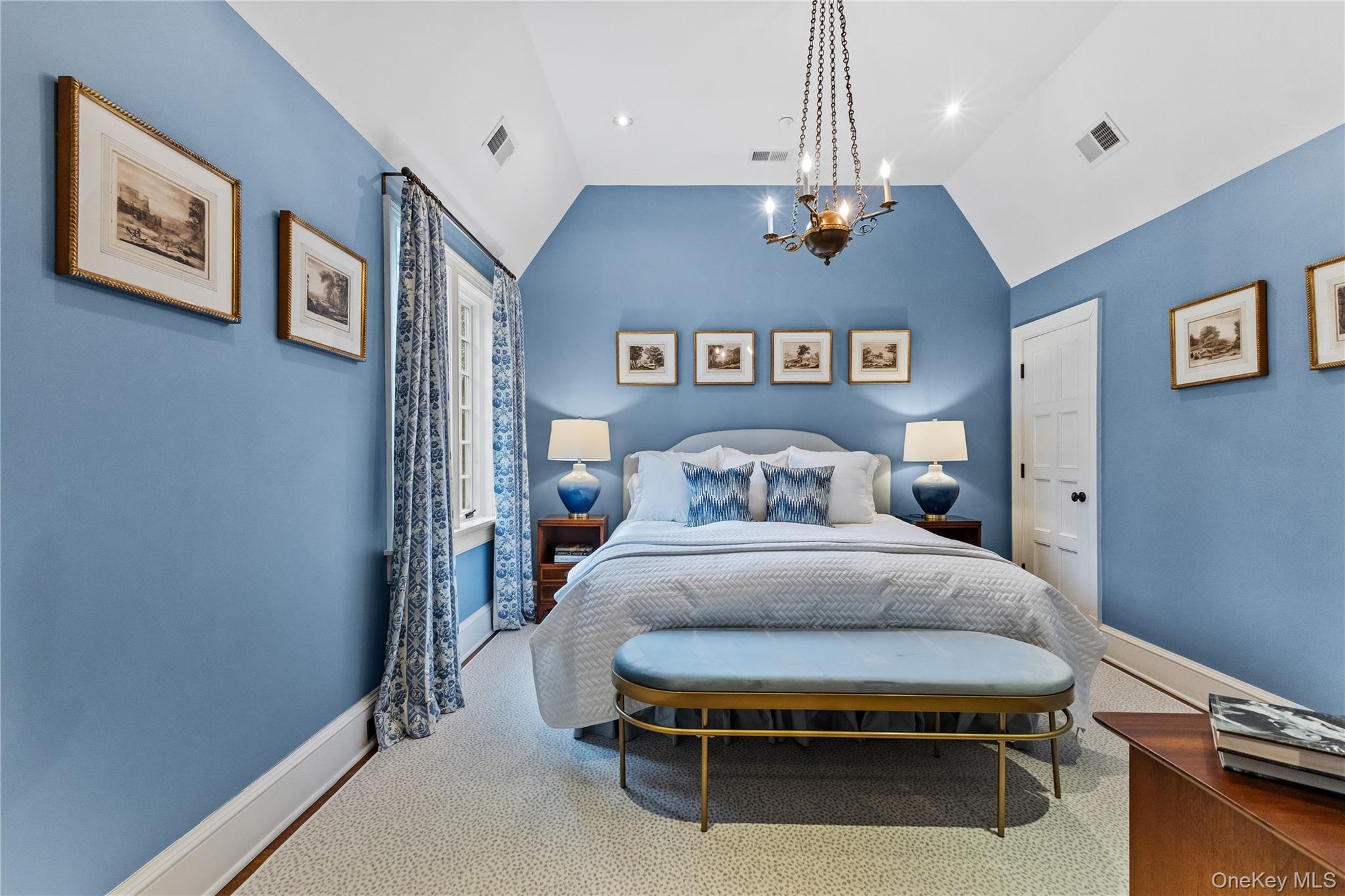 19 Park Drive South Rye, NY 10580 - Photo 28 of 42 A serene guest retreat featuring vaulted ceilings, a sophisticated blue-and-white palette, and classic architectural details that evoke a tranquil, high-end atmosphere.