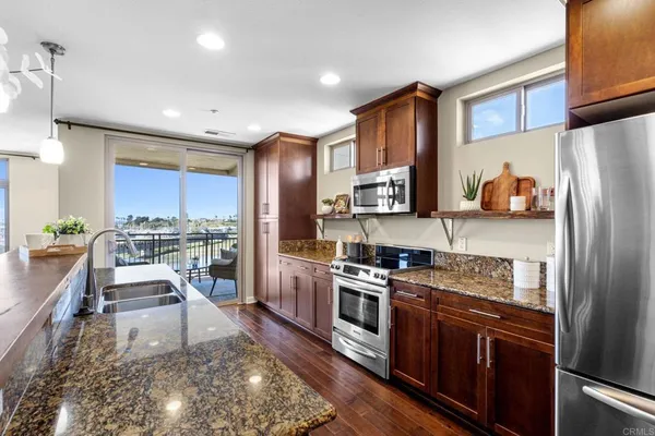 a kitchen with stainless steel appliances granite countertop a refrigerator stove microwave and sink
