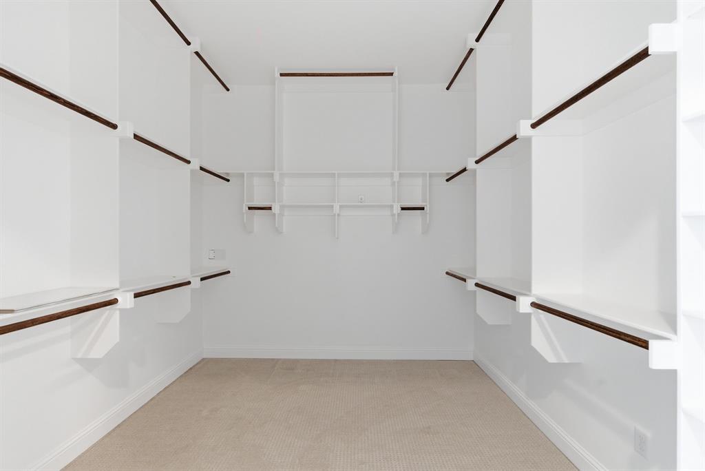 4600 Old Brock Road Weatherford, TX 76087 - Photo 22 of 37 Spacious walk-in closet featuring built-in shelving, multiple hanging rods, and neutral-toned carpeting