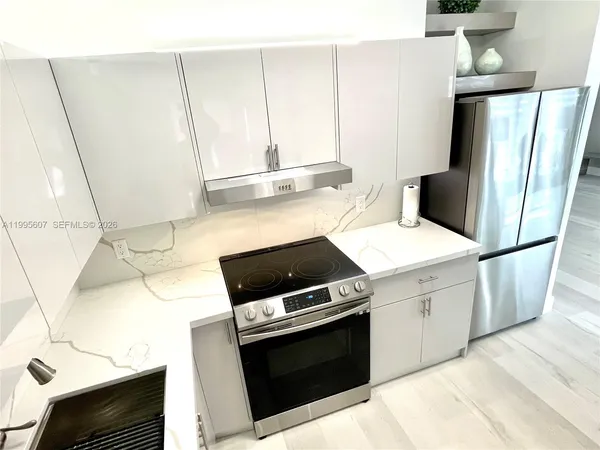 a kitchen with stainless steel appliances a stove microwave and a refrigerator