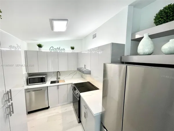 a kitchen with a sink a refrigerator and cabinets