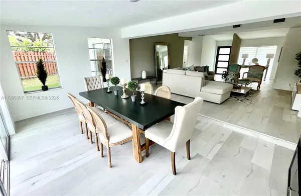 a dining room with wooden floor and large windows