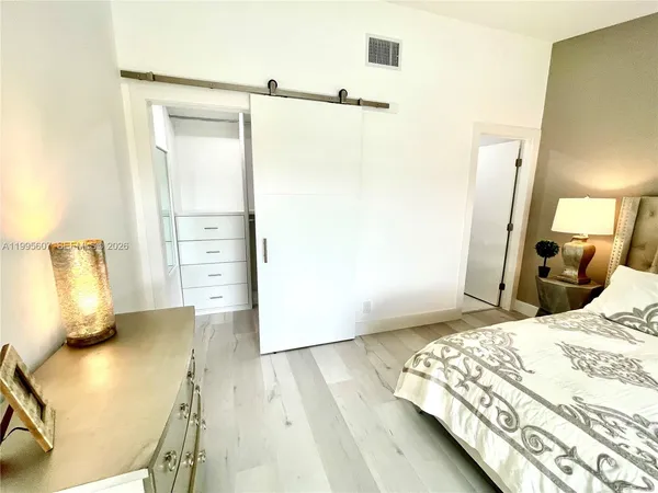 a bedroom with a bed and wooden floor