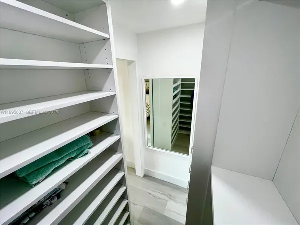 a view of walk in closet with clothes and shoes