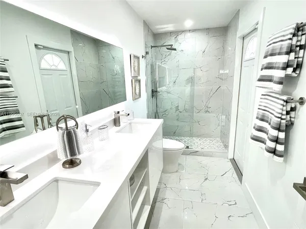 a bathroom with a double vanity sink mirror double shower and bathtub
