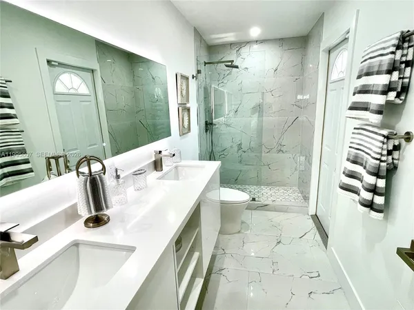 a bathroom with a double vanity sink toilet and shower