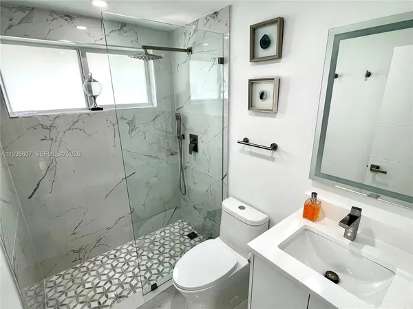 a bathroom with a sink a toilet and shower