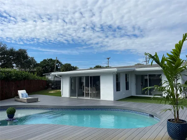 a front view of a house with swimming pool and a yard