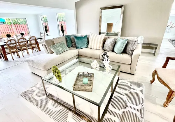 a living room with furniture and a wooden floor