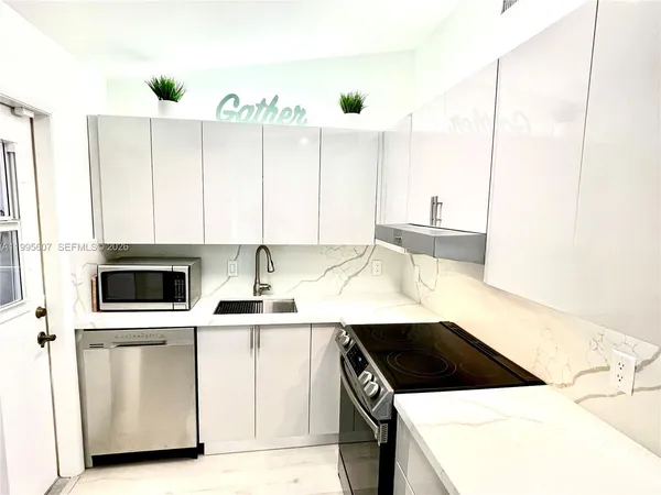 a kitchen with a sink a stove and cabinets