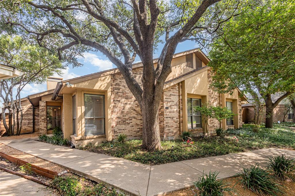 a tree in front of a white house