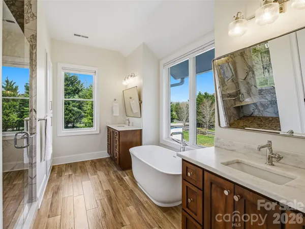 a spacious bathroom with a granite countertop sink toilet a mirror and a large window