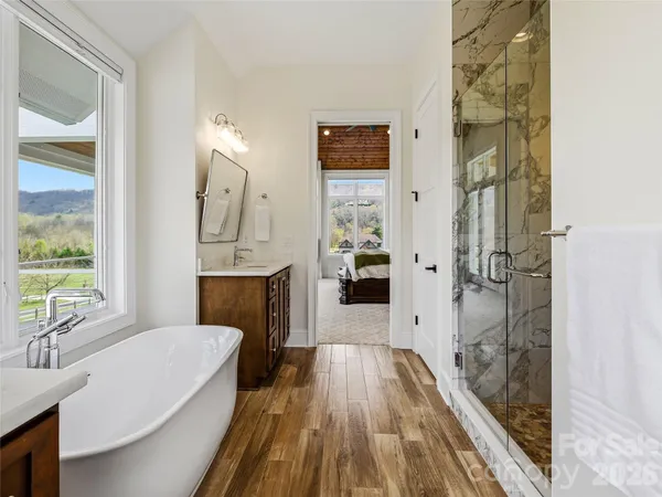 a spacious bathroom with a granite countertop tub sink shower and mirror