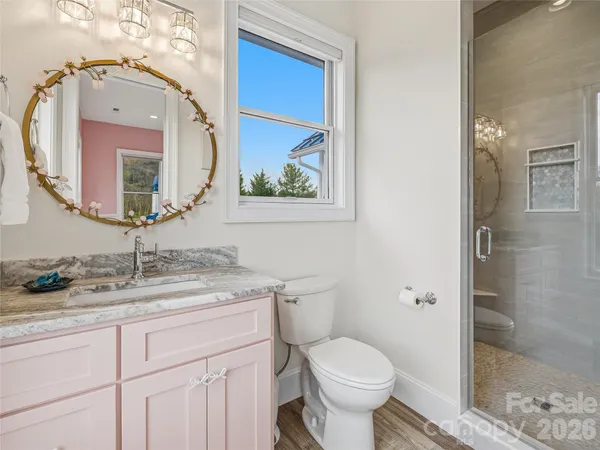 a bathroom with a granite countertop toilet sink and mirror