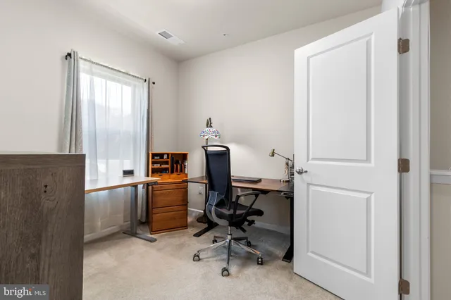 a room with furniture a air conditioner vent and a window