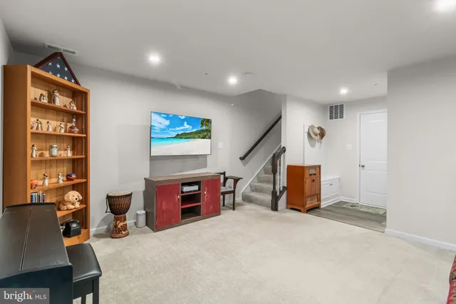 a living room with furniture a rug and a wall painting