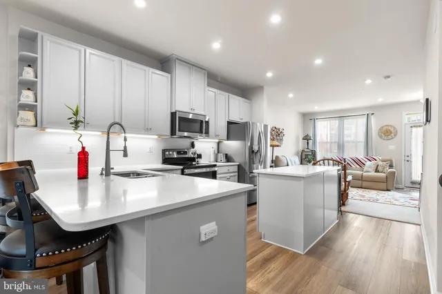 a kitchen with kitchen island a white cabinets and wooden floor