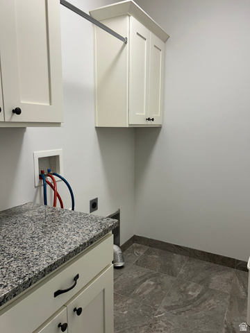 175 North 100th West Centerfield, UT 84622 - Photo 16 of 32 Dedicated utility space featuring extensive cabinet storage, a granite-finish countertop, a hanging rod, and large format floor tiles. Gas or Electric dryer capability.
