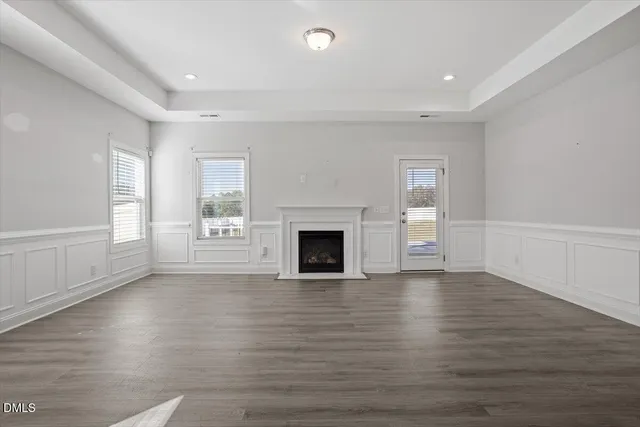 wooden floor fireplace and windows in an empty room